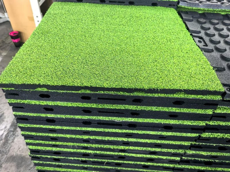 perito comparando um ladrilho de relva com um rolo de relva tradicional